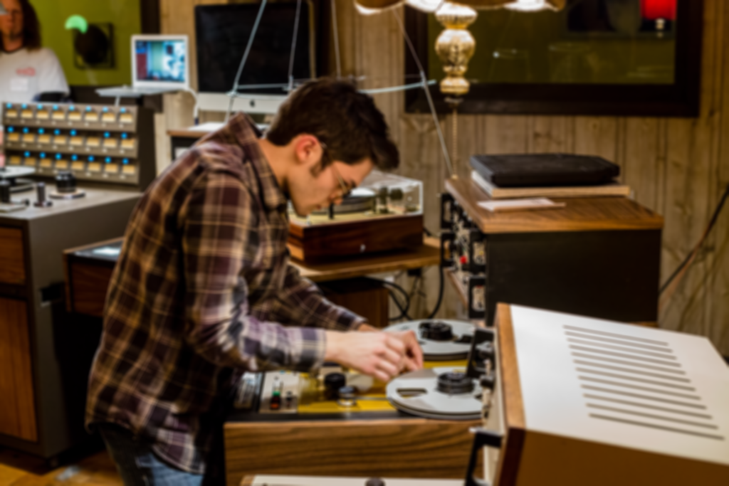 Audio Engineer Works on Tape Machine