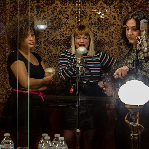 Musicians gather around vintage vocal microphone